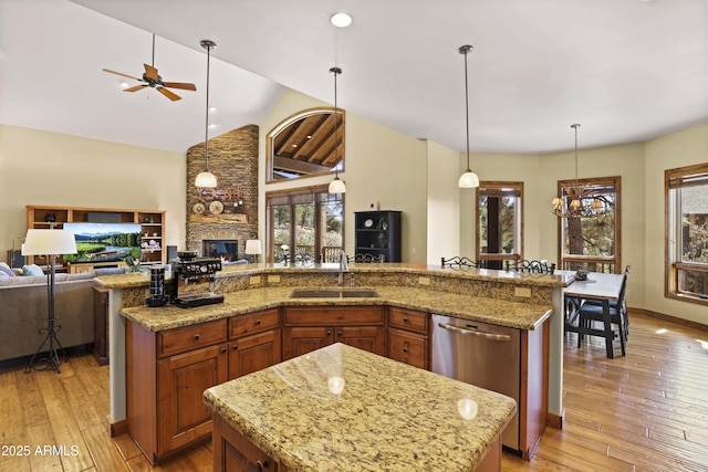 kitchen featuring a spacious island, decorative light fixtures, light hardwood / wood-style floors, and sink