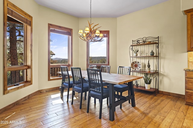 dining room with a notable chandelier and light wood-type flooring