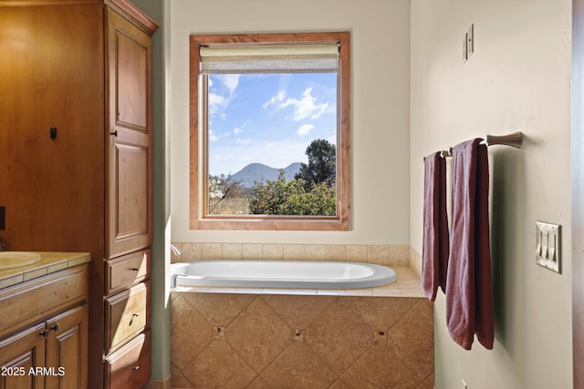 bathroom featuring vanity, a mountain view, and tiled bath