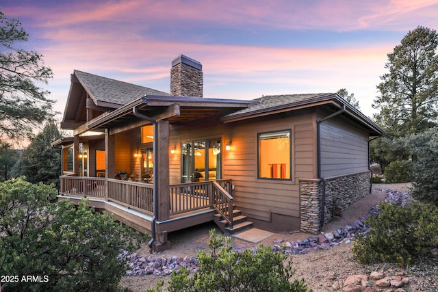 back house at dusk featuring a deck