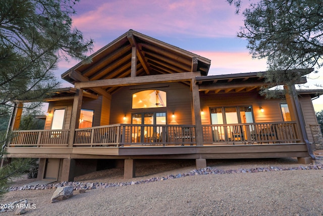 back house at dusk with a wooden deck