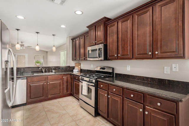 kitchen with sink, vaulted ceiling, hanging light fixtures, light tile patterned floors, and stainless steel appliances