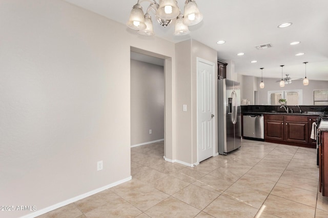 kitchen with dark brown cabinetry, sink, hanging light fixtures, light tile patterned floors, and appliances with stainless steel finishes