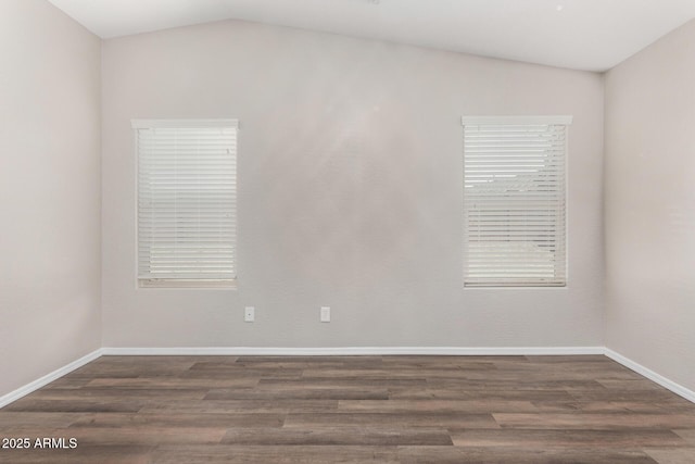 empty room with dark hardwood / wood-style flooring and vaulted ceiling