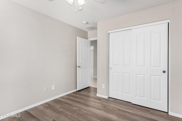 unfurnished bedroom featuring ceiling fan, hardwood / wood-style floors, and a closet