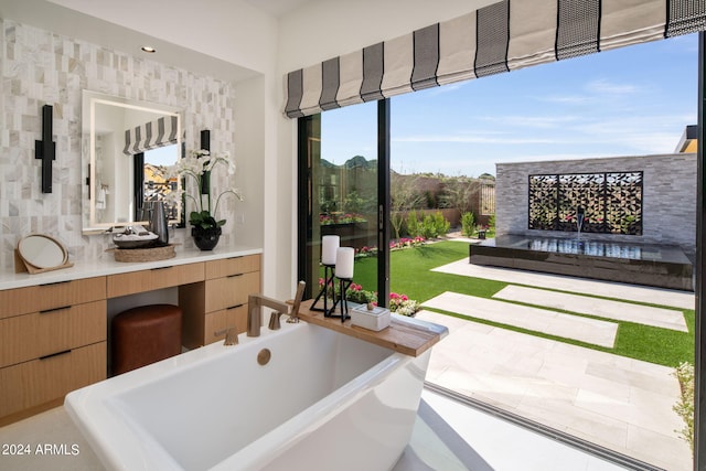 bathroom with a bath, vanity, and a healthy amount of sunlight