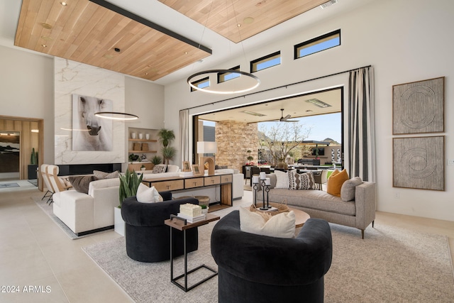 living room with a high end fireplace, wooden ceiling, and a high ceiling