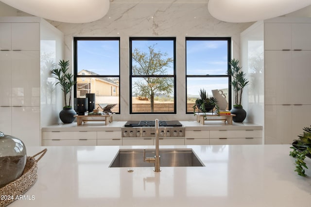 kitchen with white cabinetry, sink, and stainless steel gas stovetop