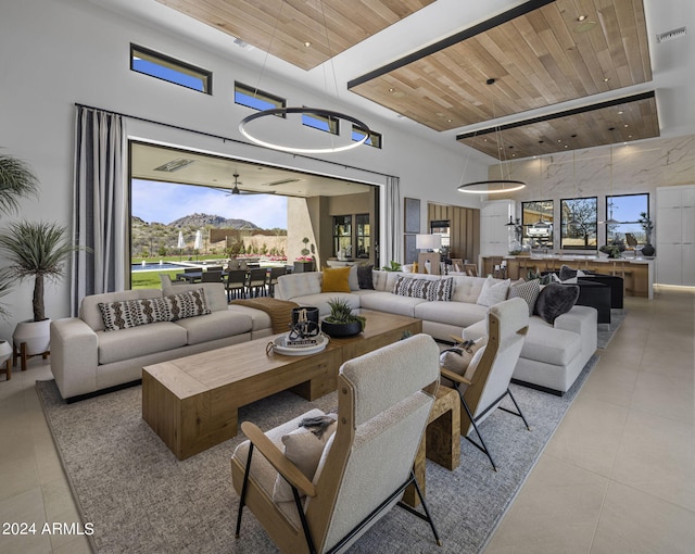 living room featuring a wealth of natural light, a mountain view, a towering ceiling, and wood ceiling