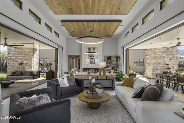 living room featuring ceiling fan, wood ceiling, and a high ceiling