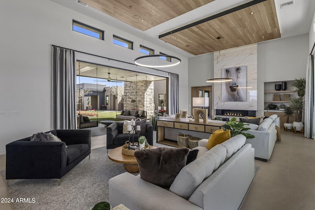 living room with a high ceiling, built in features, and wood ceiling