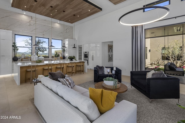 living room featuring a towering ceiling and wooden ceiling