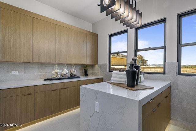 kitchen featuring light brown cabinets, a center island, and tasteful backsplash