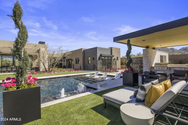 view of pool with pool water feature, area for grilling, grilling area, and a patio area