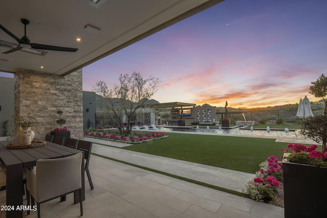24046 N 126th Pl, Scottsdale, AZ 85255 - patio terrace at dusk with a yard, a patio area, ceiling fan, and outdoor dining space