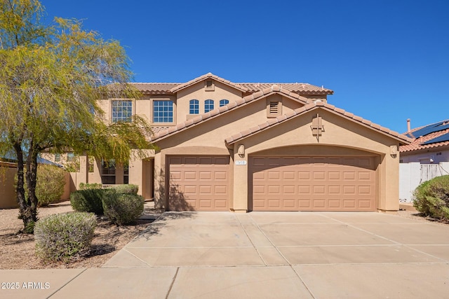 mediterranean / spanish-style home with stucco siding, driveway, a garage, and a tile roof
