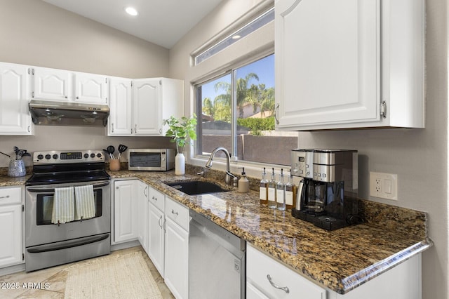 kitchen featuring stainless steel appliances, white cabinetry, sink, and dark stone countertops