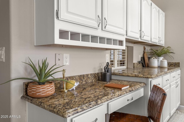 kitchen with dark stone countertops and white cabinets