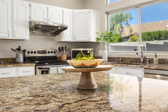 kitchen featuring appliances with stainless steel finishes, sink, dark stone countertops, and white cabinets