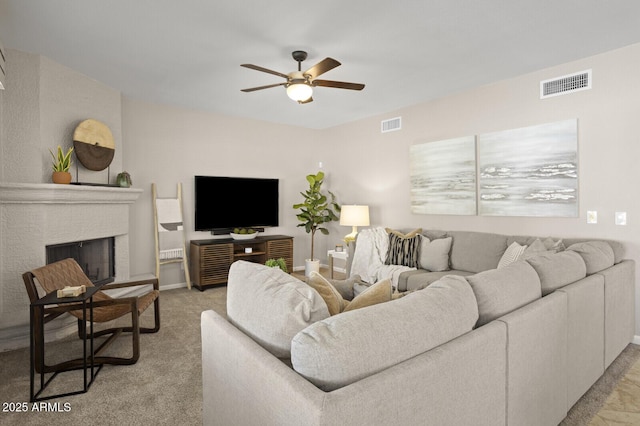 living room featuring ceiling fan, light carpet, and a brick fireplace