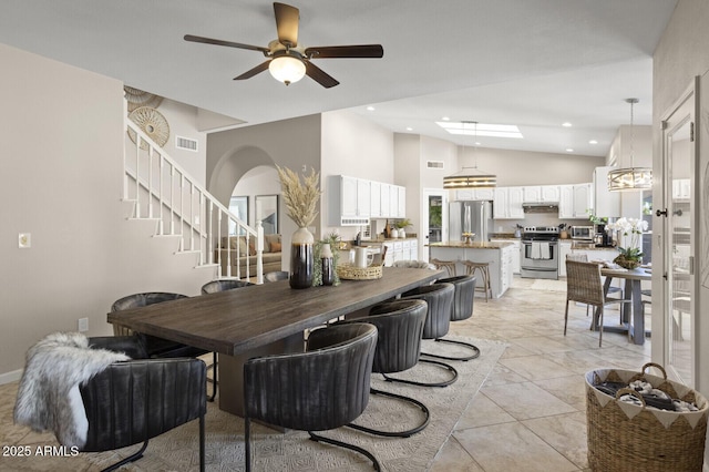 tiled dining area with vaulted ceiling and ceiling fan