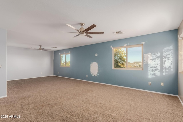 carpeted empty room featuring a healthy amount of sunlight and ceiling fan