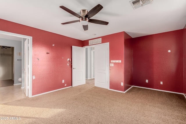 unfurnished bedroom featuring ensuite bath, carpet floors, and ceiling fan