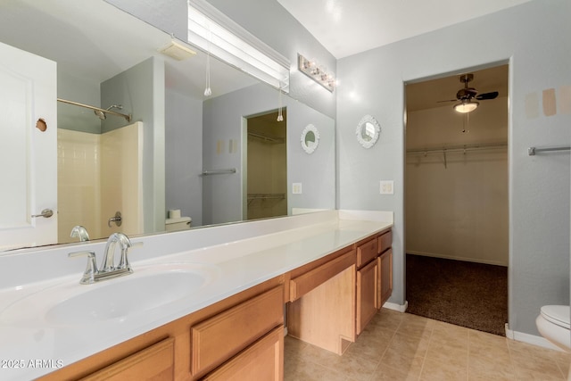 bathroom featuring ceiling fan, vanity, toilet, and a shower