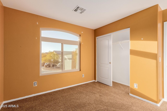 unfurnished bedroom featuring carpet floors and a closet