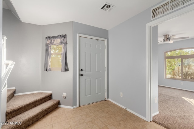 carpeted foyer with ceiling fan