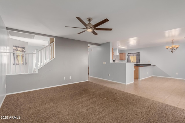 unfurnished living room with light carpet and ceiling fan with notable chandelier