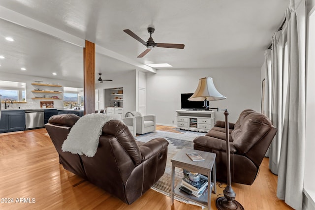 living room with light hardwood / wood-style floors, sink, and ceiling fan