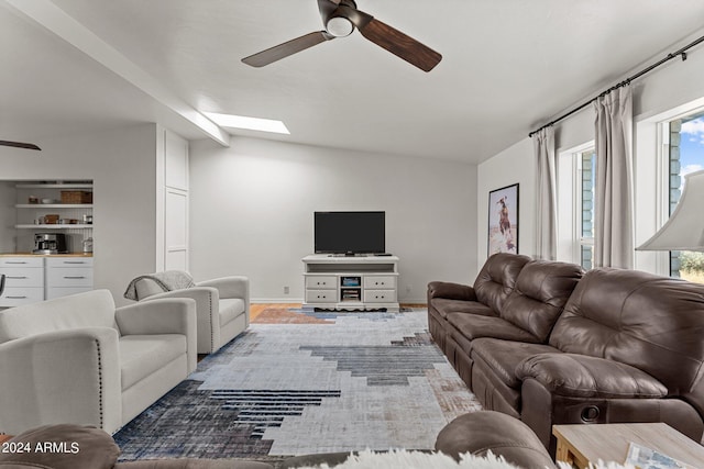 living room featuring ceiling fan, hardwood / wood-style floors, and vaulted ceiling