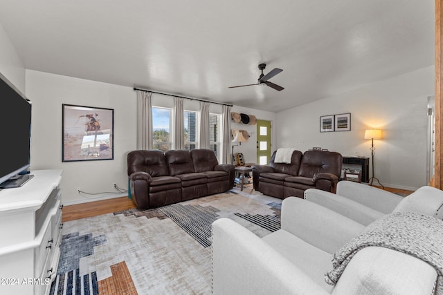 living room featuring light hardwood / wood-style floors, lofted ceiling, and ceiling fan