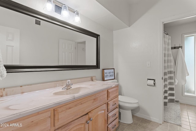 bathroom featuring tile patterned floors, vanity, and toilet