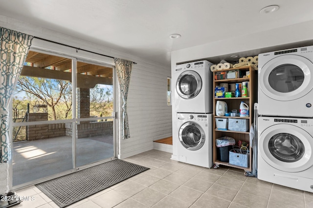 laundry area featuring light tile patterned flooring and stacked washing maching and dryer