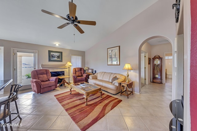 16230 E Glenpoint Dr, Fountain Hills, AZ 85268 - living area with light tile patterned flooring, high vaulted ceiling, arched walkways, a ceiling fan, and a premium fireplace