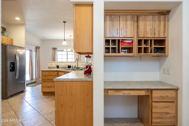 kitchen with hanging light fixtures, stainless steel refrigerator with ice dispenser, sink, and light tile patterned floors