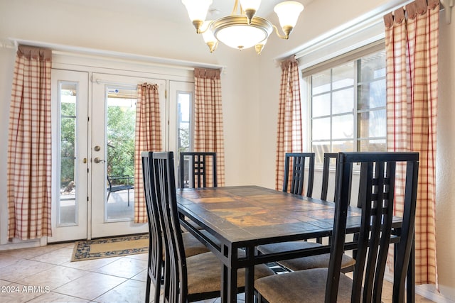 dining area featuring french doors, a chandelier, and tile patterned floors