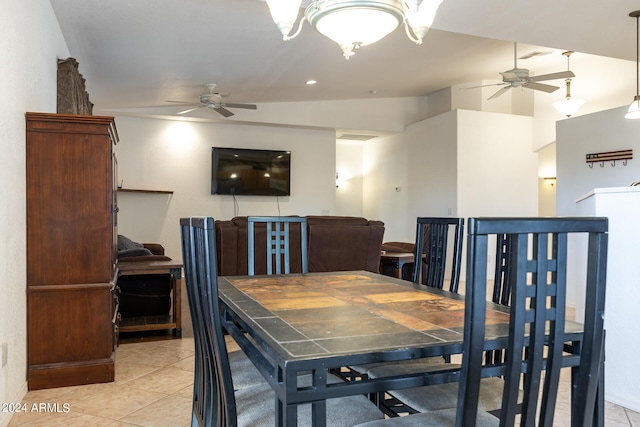 dining area with ceiling fan with notable chandelier, lofted ceiling, and light tile patterned floors