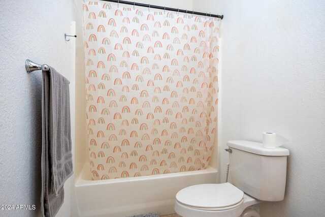 bathroom featuring shower / bath combination with curtain and toilet