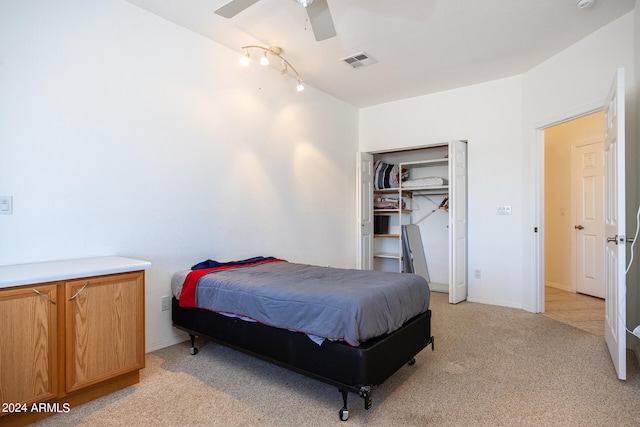 bedroom with ceiling fan, light colored carpet, and a closet