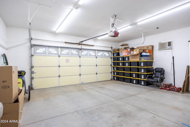 garage with an AC wall unit and a garage door opener