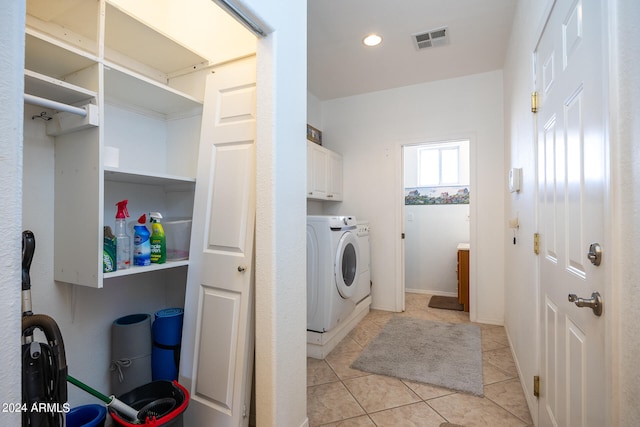 clothes washing area featuring cabinets, independent washer and dryer, and light tile patterned floors