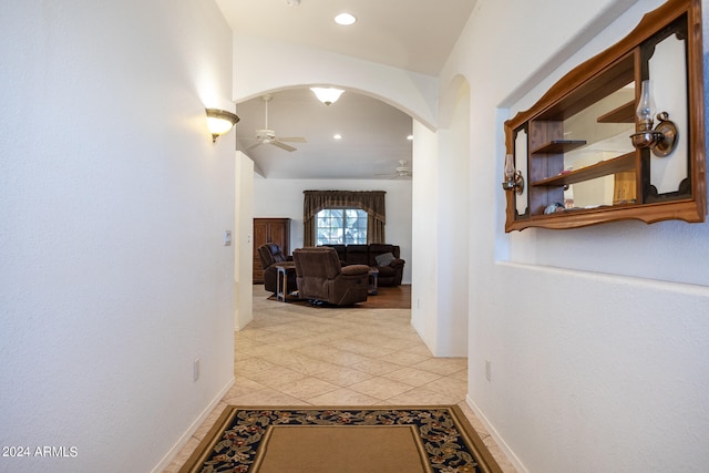 corridor with vaulted ceiling and light tile patterned floors