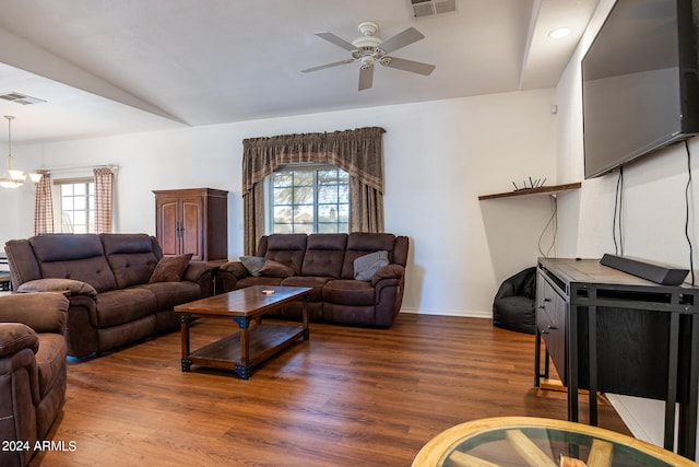 living room with a healthy amount of sunlight, ceiling fan with notable chandelier, vaulted ceiling, and dark wood-type flooring