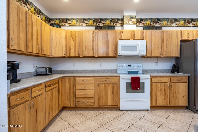 kitchen with light tile patterned floors and white appliances