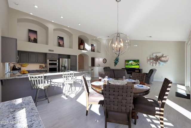 dining area with high vaulted ceiling and an inviting chandelier