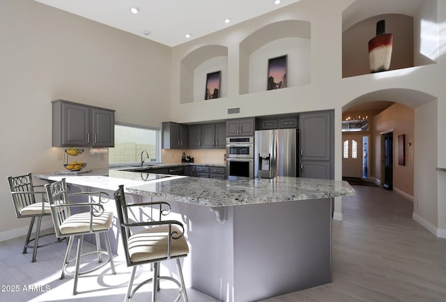 kitchen with a center island, stainless steel appliances, and gray cabinets