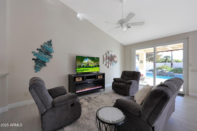 living room with ceiling fan, light wood-type flooring, and vaulted ceiling